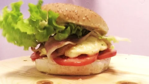 Hamburger is formed in slow motion with lettuce, cheese, bacon and tomato Stock Footage 139918985