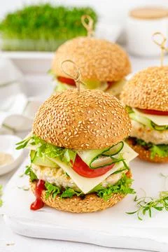 Hamburger with grilled chicken burger, fresh cucumber, tomato, cheese and let Stock Photos