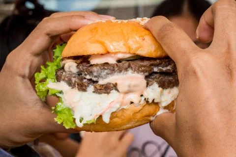 Hamburger in the hand. Stock Photos