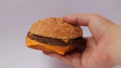 Hamburger in hand on white background Stock-Footage 106289193