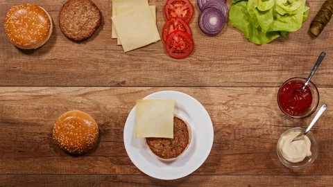 Hamburger ingredients assembling a delicious burger Stock Footage 82797876