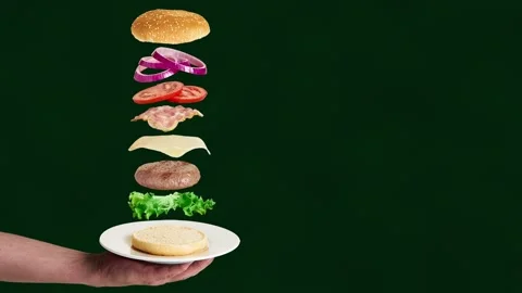 Hamburger ingredients falling on the bun. Stock Footage 169628486