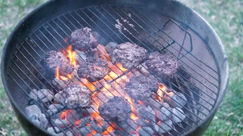 Hamburger patties catching fire while cooking over a charcoal grill. Видео 135218711