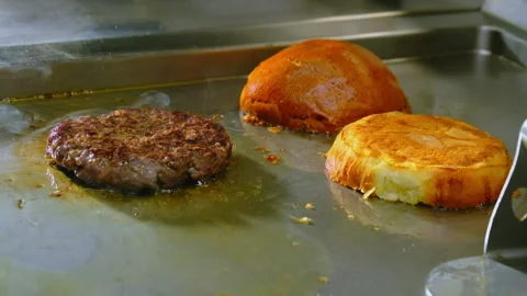 Hamburger patty and split bun fry in pan releasing tempting smell Video stock 325024245