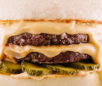 Hamburger with two cutlets, pickled cucumbers and melted cheese Foto stock