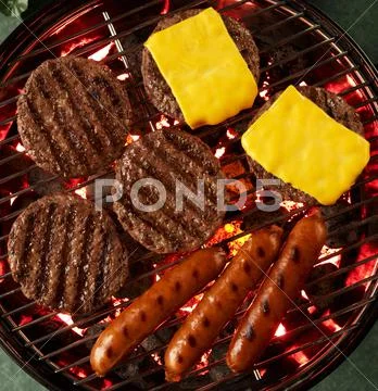 Hamburgers, Cheeseburgers and Hot Dogs on a Grill; From Above Stock Photos