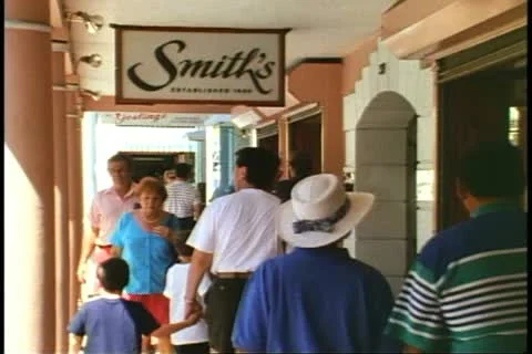 HAMILTON, BERMUDA, 1994, Crowd under the arcade, Smiths sign, shop Stock Footage 12234146