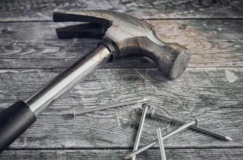 Hammer and a bunch of construction nails closeup. Repair concept. Stock Photos