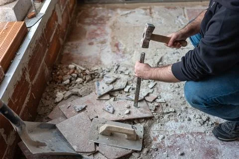 Hammer and chisel worker for manual demolition of floors and walls in house.. Stock Photos