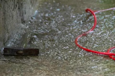 Hammer and red cable at a construction site during a major rain. Foto stock