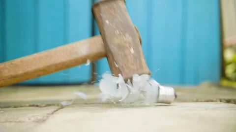 Hammer breaks light bulb on the ground in slow motion 库存影片 112689495
