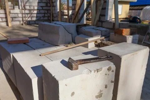 The hammer on the bricks of foam concrete. Stock Photos