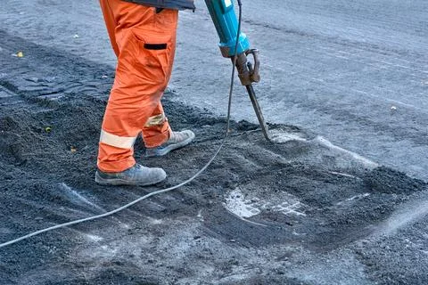Hammer drill.Road worker breaks up old asphalt with jackhammer Stock Photos