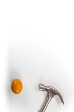 Hammer hitting a egg isolated on white with copy space. Stock Photos
