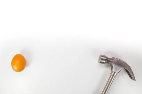 Hammer hitting a egg isolated on white with copy space. Stock Photos