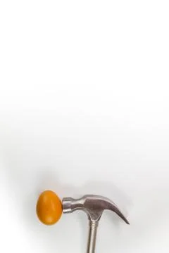 Hammer hitting a egg isolated on white with copy space. Stock Photos