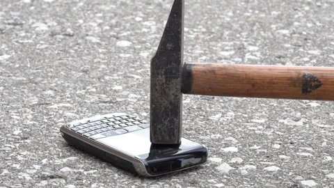 A hammer hitting the screen of a smart phone blackberry Stock Footage 154549622