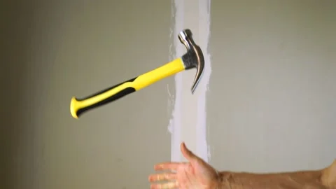 Hammer a nail into the Board.A construction worker throws and catch Vídeos de archivo 141493700
