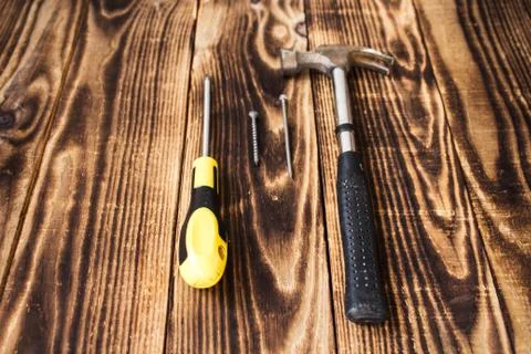 Hammer nail, screw and screwdriver on wooden background Stock Photos