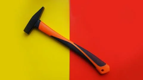 Hammer tool isolated on yellow and red background with copy space Stock Photos