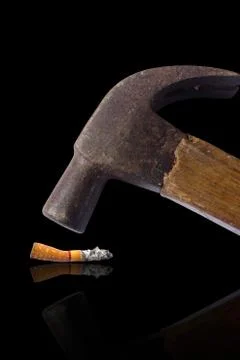 Hammered cigarette isolated on black, hate and anti concept. Stock Photos