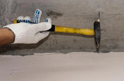 Hammering the dowel into the ceiling. Stock Photos