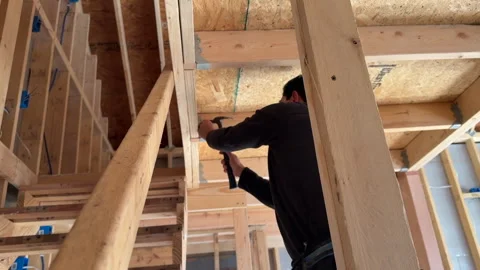 Hammering joist hangers to studs and rafters Stock Footage 332591634