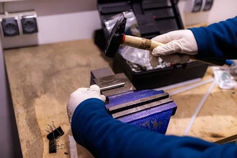 Hammering Metal Pin into Component Fixed in Bench Vise, Manual Assembly Work in Fotos de archivo