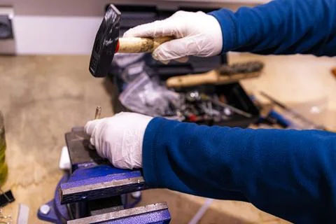 Hammering Metal Pin into Component Fixed in Bench Vise, Manual Assembly Work in Foto stock