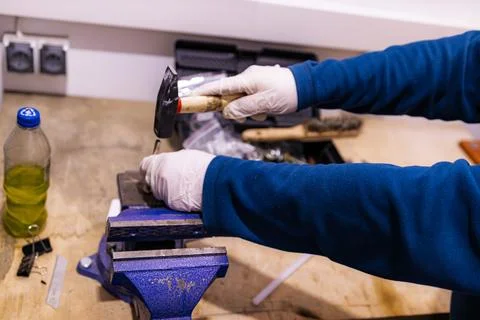 Hammering Metal Pin into Component Fixed in Bench Vise, Manual Assembly Work in Foto stock