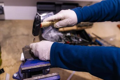 Hammering Metal Pin into Component Fixed in Bench Vise, Manual Assembly Work in Stock-Fotos