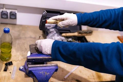 Hammering Metal Pin into Component Fixed in Bench Vise, Manual Assembly Work in Fotos de archivo