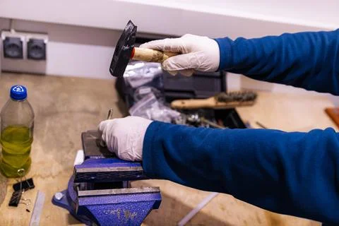 Hammering Metal Pin into Component Fixed in Bench Vise, Manual Assembly Work in Foto stock