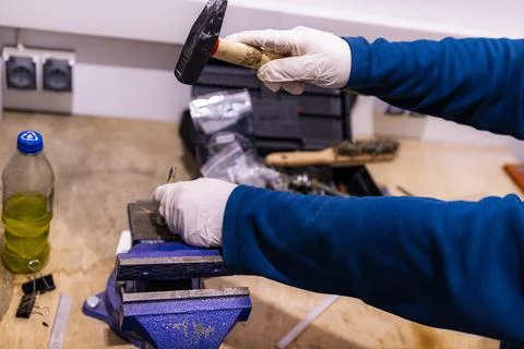 Hammering Metal Pin into Component Fixed in Bench Vise, Manual Assembly Work in Stock Photos