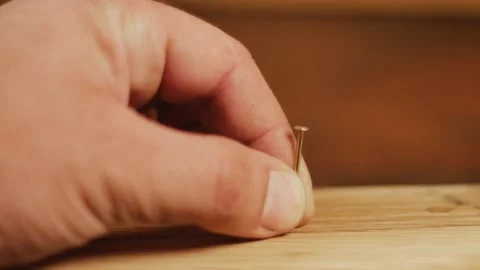 Hammering a nail into a board 库存影片 173622821