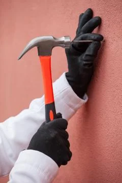 Hammering a nail into a wall Stock Photos