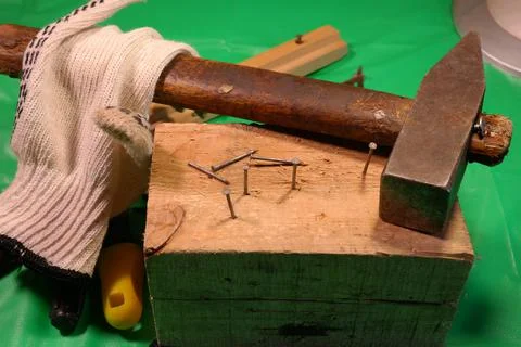 Hammering nails. Using a hammer and a nail. Close up of hammering a nail into Stock Photos