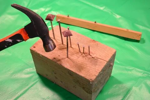 Hammering nails. Using a hammer and a nail. Close up of hammering a nail into Stock Photos