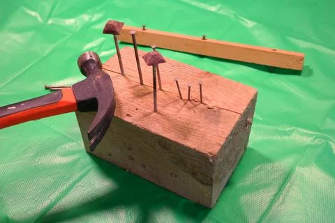Hammering nails. Using a hammer and a nail. Close up of hammering a nail into Photos