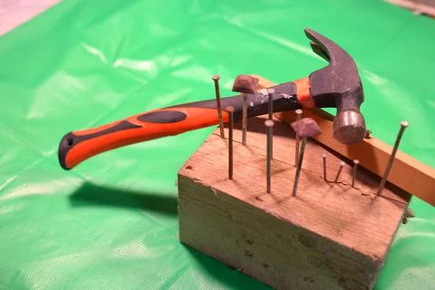 Hammering nails. Using a hammer and a nail. Close up of hammering a nail into 写真素材