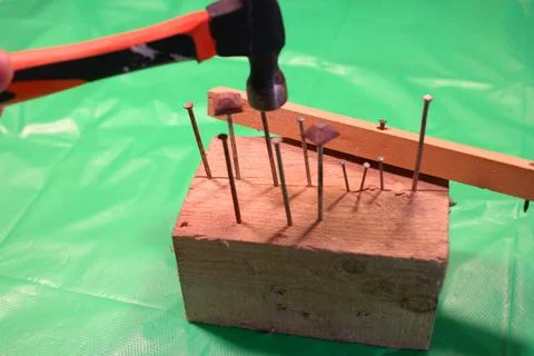 Hammering nails. Using a hammer and a nail. Close up of hammering a nail into Stock Photos