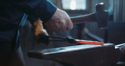 Hammering an rustic piece of iron in blacksmith's forge Stock Footage 105295303