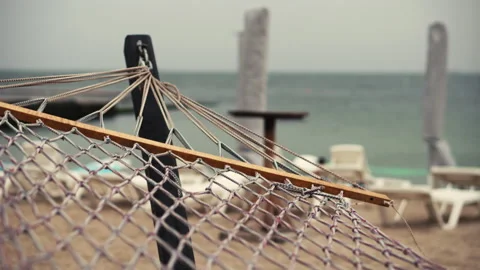 Hammock on the beach of the sea coast on a cloudy autumn day during a cyclone. C Stock Footage 138962596