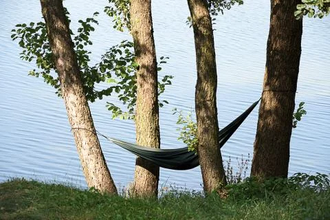A hammock between the trees at the lakeside Stock Photos