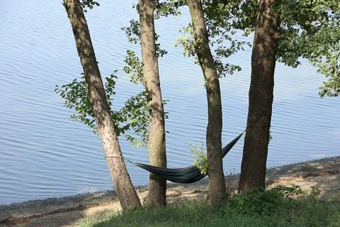 A hammock between the trees at the lakeside Stock Photos