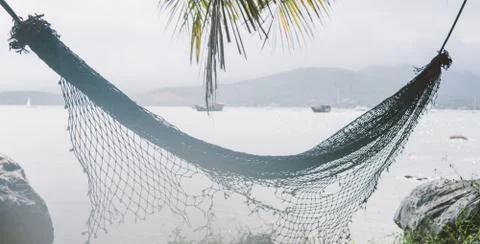 Hammock hanging on the background of the ocean close-up. .Concept of relaxati Stock Photos