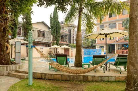Hammock hanging by a pool side with no people around Stock-Fotos