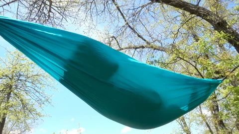 Hammock with a resting man inside in 4K Stock Footage 153612242