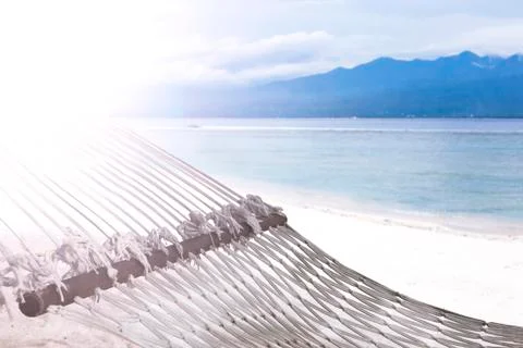 Hammock on sandy beach on background of azure Bali Sea. Coast of the Gili Stock Photos