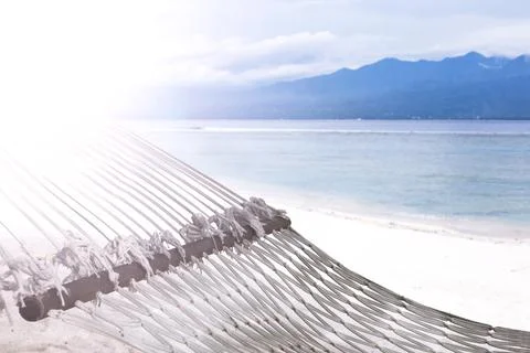 Hammock on sandy beach on background of azure Bali Sea. Coast of the Gili Foto stock